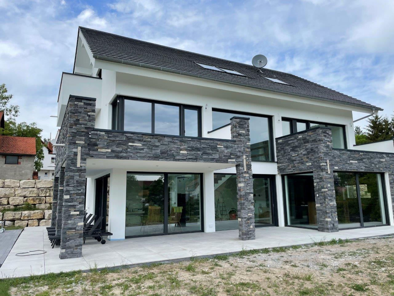 Modern Home mit Broken Rock Nordica-Verblendung an Säulen und Balkon